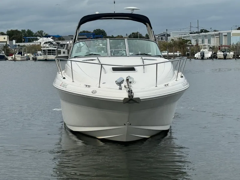 Slide: The Image of 2003 Sea Ray 320 Sundancer boat on calm water, marina background. - 6