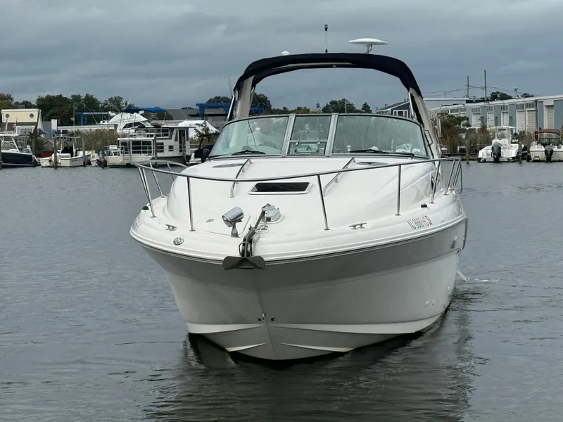 Slide: The Image of 2003 Sea Ray 320 Sundancer boat on calm water, marina background. - 7