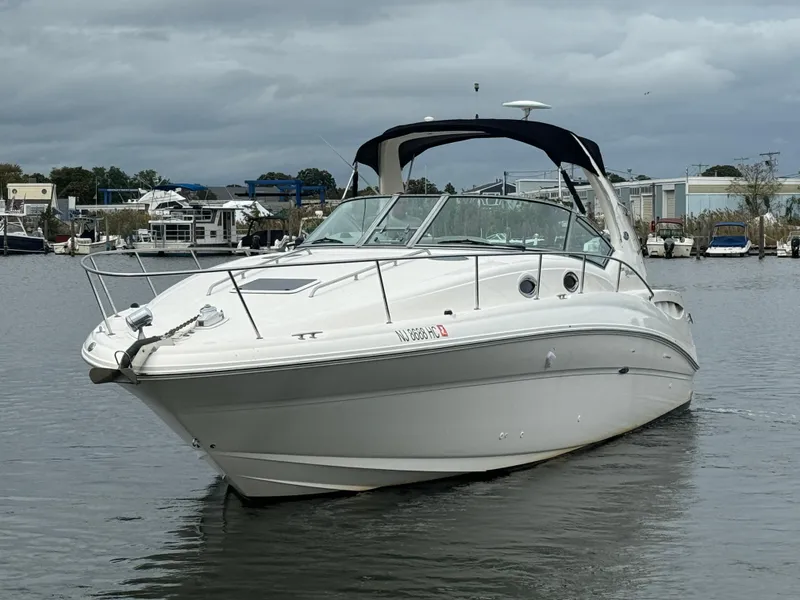 Slide: The Image of 2003 Sea Ray 320 Sundancer boat on calm water, overcast sky. - 8