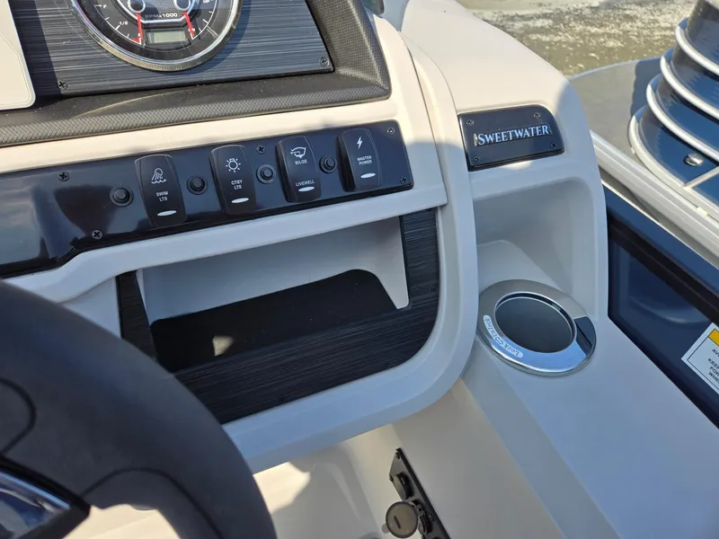 Slide: The Image of Dashboard of 2025 Godfrey SWEETWATER Entertainment 2486 DT boat with control panel and cup holder. - 18