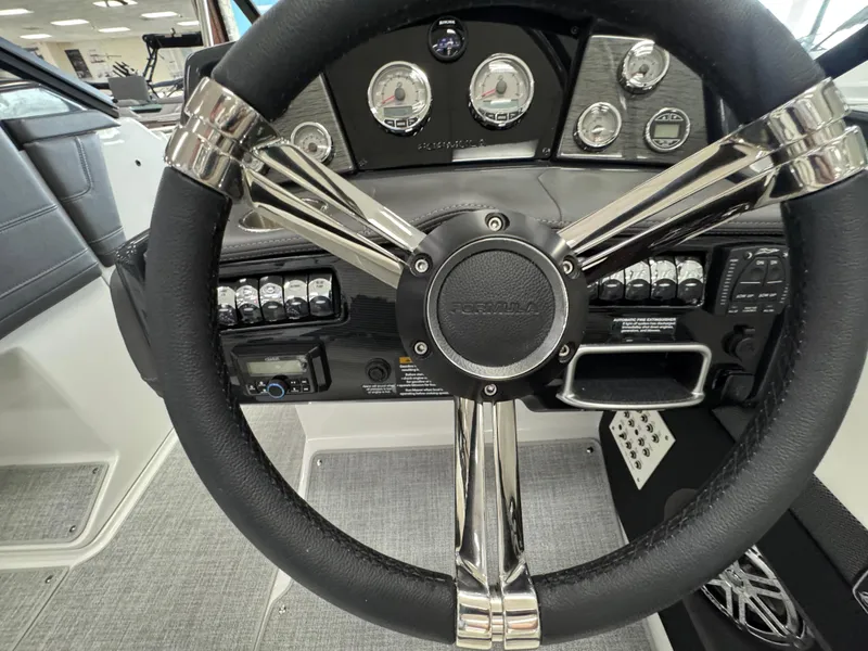 Slide: The Image of Steering wheel and dashboard of 2025 Formula 240 BR boat, featuring modern controls and gauges. - 17