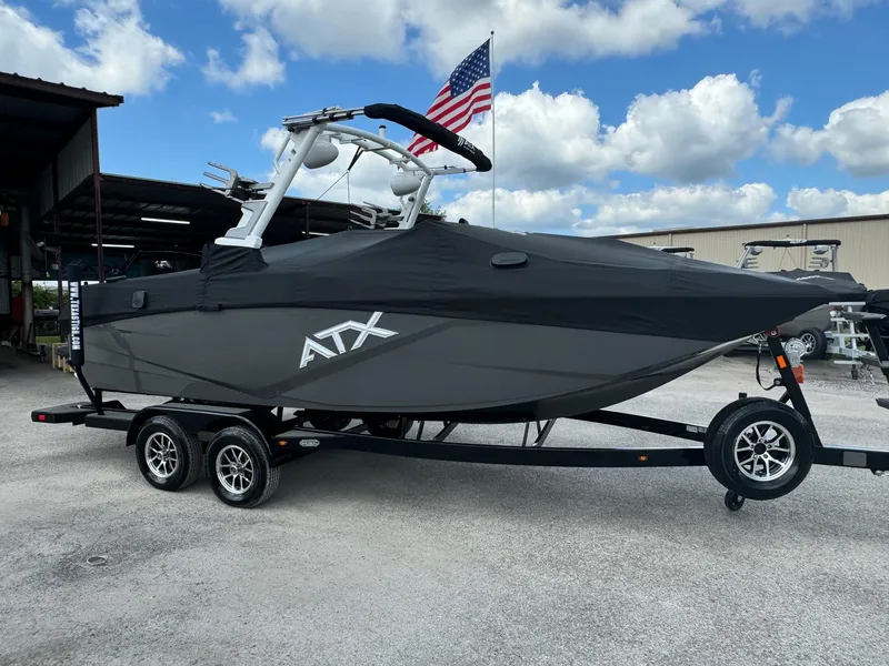 Slide: The Image of 2025 ATX Surf Boats 22 Type-S on trailer, covered, with American flag in background. - 4