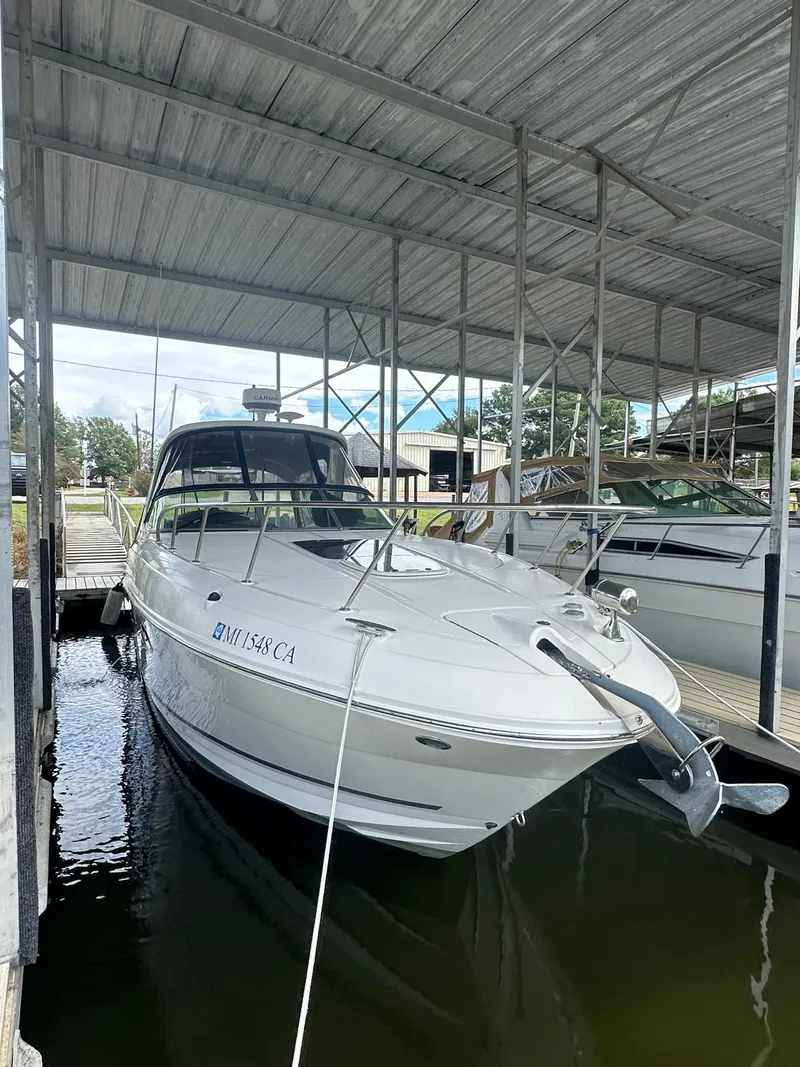 Slide: The Image of 2012 Sea Ray 310 Sundancer docked under a covered marina. - 10