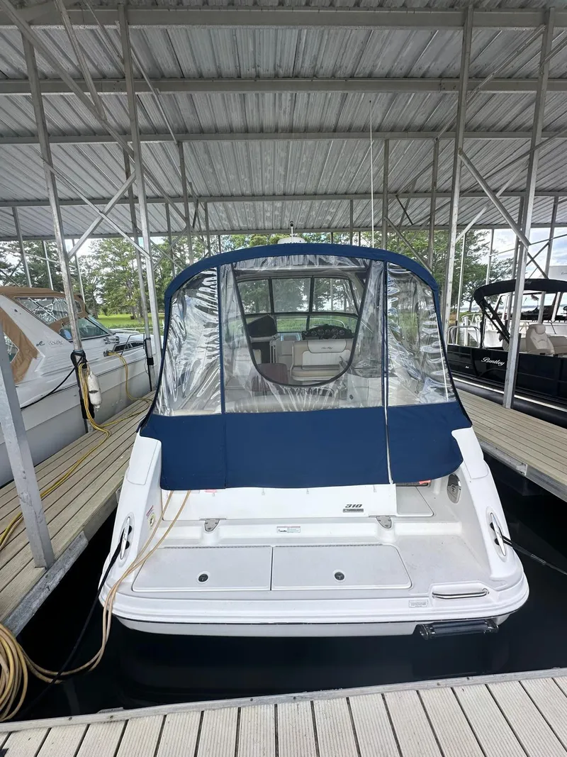 Slide: The Image of 2012 Sea Ray 310 Sundancer docked with blue canopy and clear enclosure. - 11