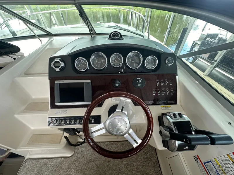 Slide: The Image of Helm of 2012 Sea Ray 310 Sundancer with gauges, steering wheel, and controls. - 3