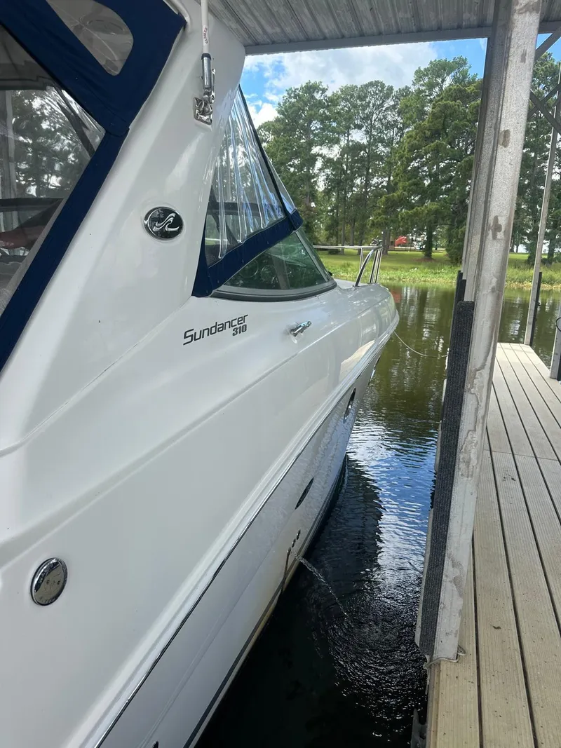 Slide: The Image of 2012 Sea Ray 310 Sundancer docked by a serene lakeside. - 4