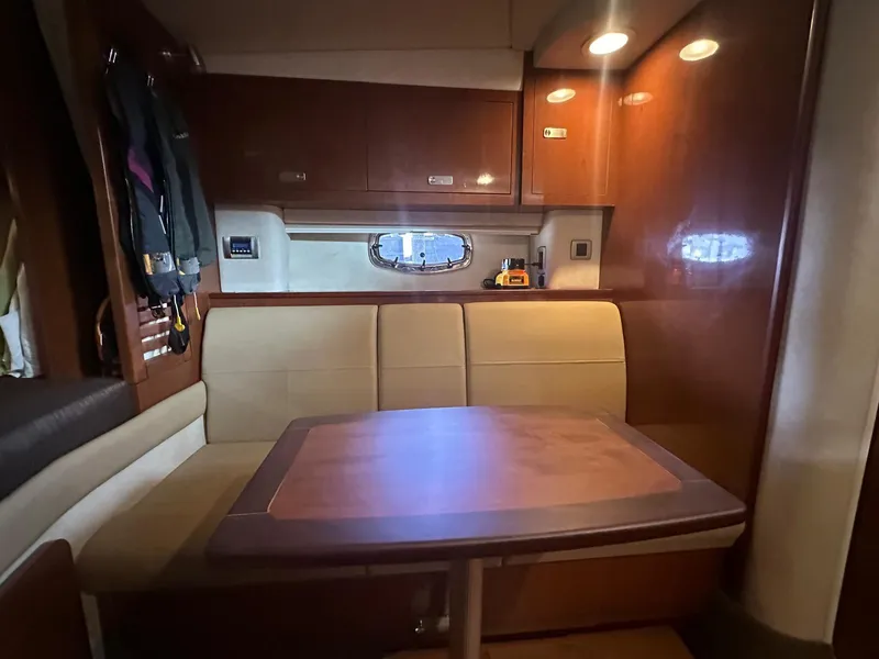 Slide: The Image of Interior of 2012 Sea Ray 310 Sundancer with wooden table and beige seating. - 5
