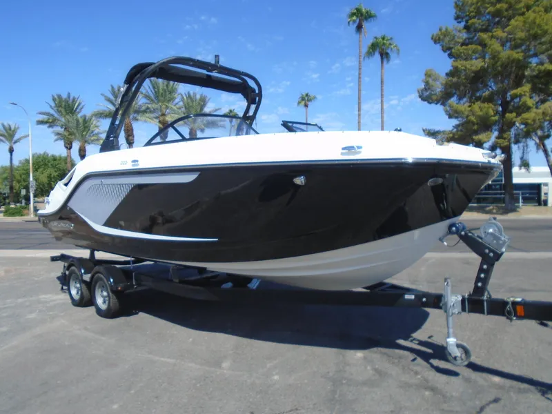 The Image of 2025 Bayliner D22I boat on trailer, parked outdoors with palm trees in background. - 1