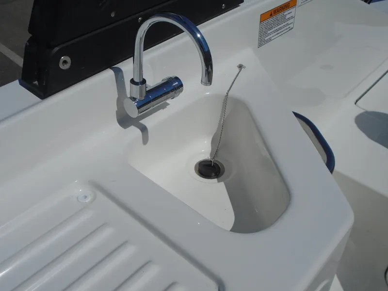 Slide: The Image of Bayliner D22I 2025 boat sink with chrome faucet and drain plug. - 15