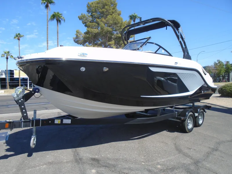 Slide: The Image of 2025 Bayliner D22I boat on trailer, black and white design, parked outdoors. - 2