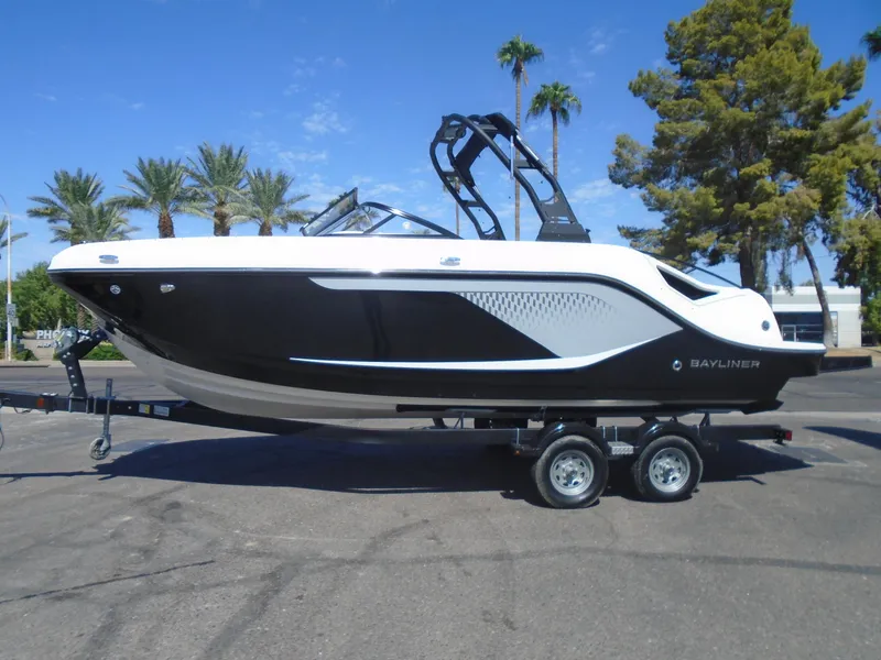 Slide: The Image of 2025 Bayliner D22I boat on trailer, sleek black and white design, parked outdoors. - 5
