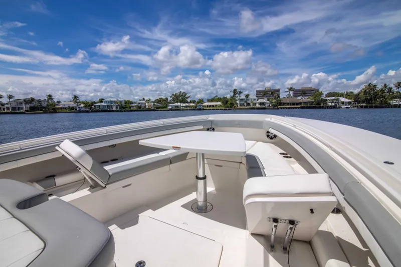 Slide: The Image of 2021 Regulator 41 boat with spacious seating and table on a sunny day. - 10