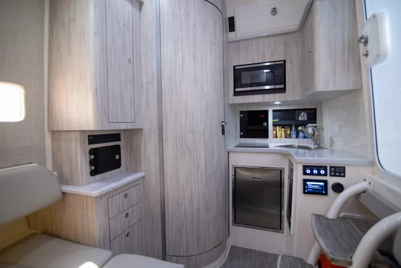 Slide: The Image of Modern 2021 Regulator 41 boat interior with kitchenette, microwave, and storage cabinets. - 22