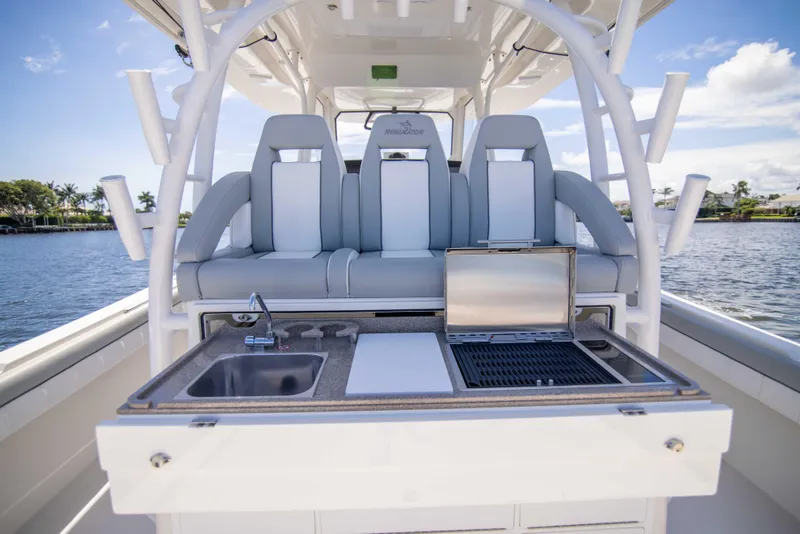 Slide: The Image of 2021 Regulator 41 boat with outdoor kitchen and seating, docked by the water. - 31
