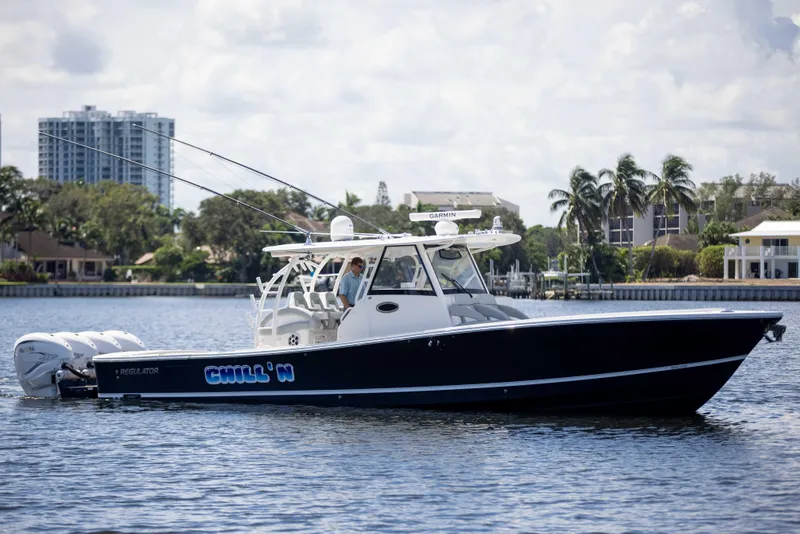 Slide: The Image of 2021 Regulator 41 boat on water, sleek design, palm trees in background. - 44