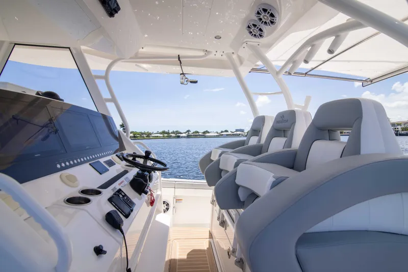 Slide: The Image of 2021 Regulator 41 boat interior with helm and seating, overlooking calm waters. - 7