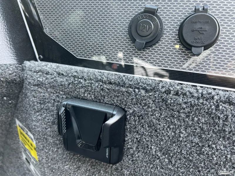 Slide: The Image of 2025 Lund 1675 Adventure Sport interior with 12V and USB ports, gray carpeted panel. - 11