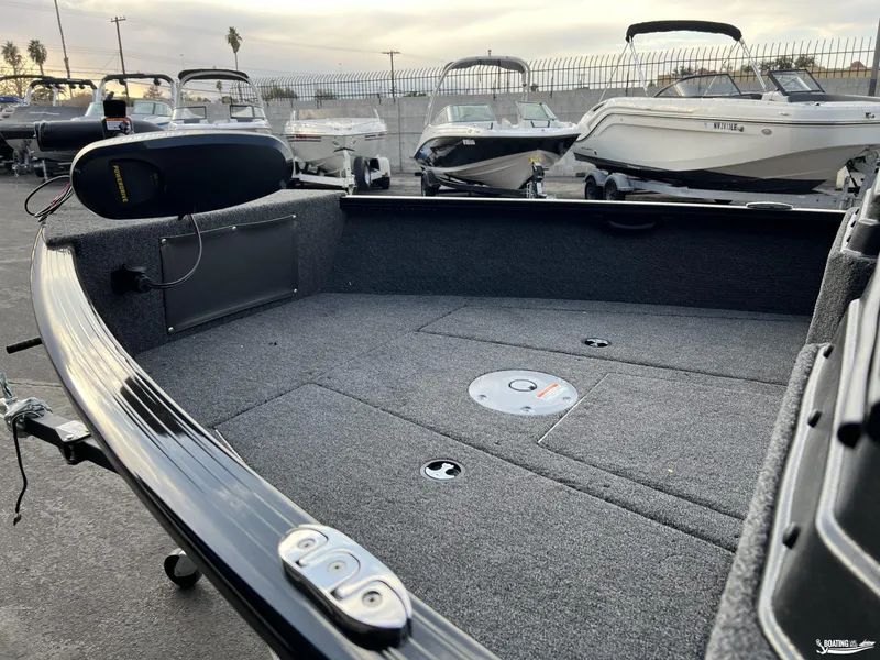 Slide: The Image of 2025 Lund 1675 Adventure Sport boat interior with carpeted deck and storage compartments. - 13