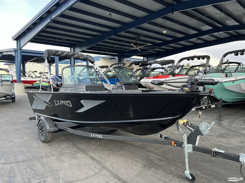 Slide: The Image of 2025 Lund 1675 Adventure Sport boat in showroom, black exterior, on trailer. - 2