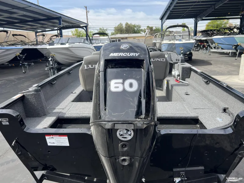 Slide: The Image of 2025 Lund 1650 Rebel XL Blackout Package with Mercury 60 engine in a boat dealership. - 11