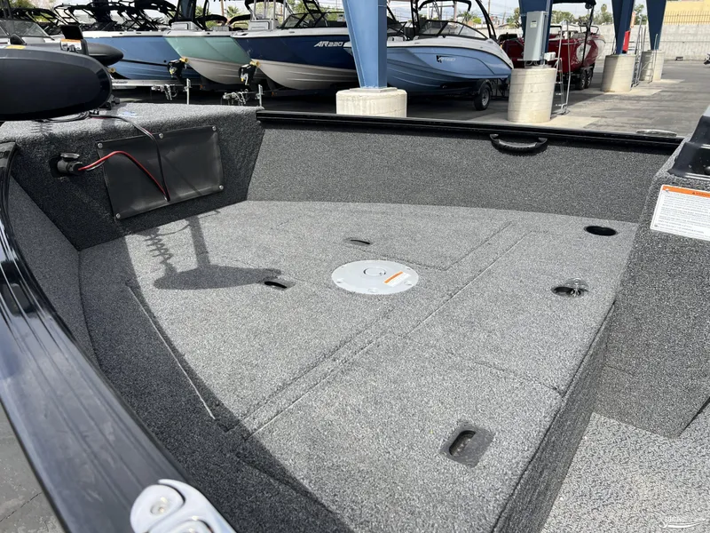 Slide: The Image of 2025 Lund 1650 Rebel XL Blackout Package boat interior with gray carpet and storage compartments. - 4
