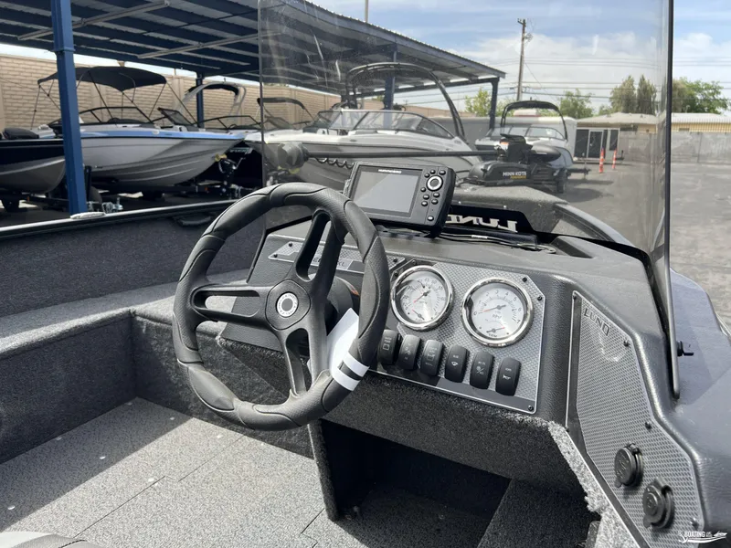 Slide: The Image of 2025 Lund 1650 Rebel XL Blackout Package boat dashboard with steering wheel and gauges. - 6