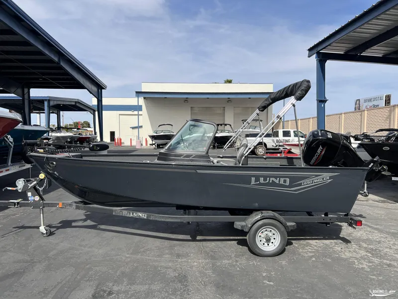 Slide: The Image of 2025 Lund 1650 Angler Sport boat on trailer in outdoor showroom. - 0