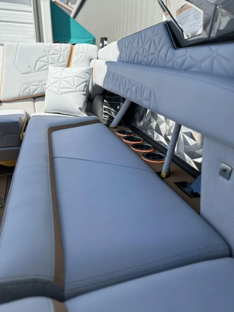 Slide: The Image of 2025 Nautique Paragon 25 interior with luxurious seating and cup holders. - 13