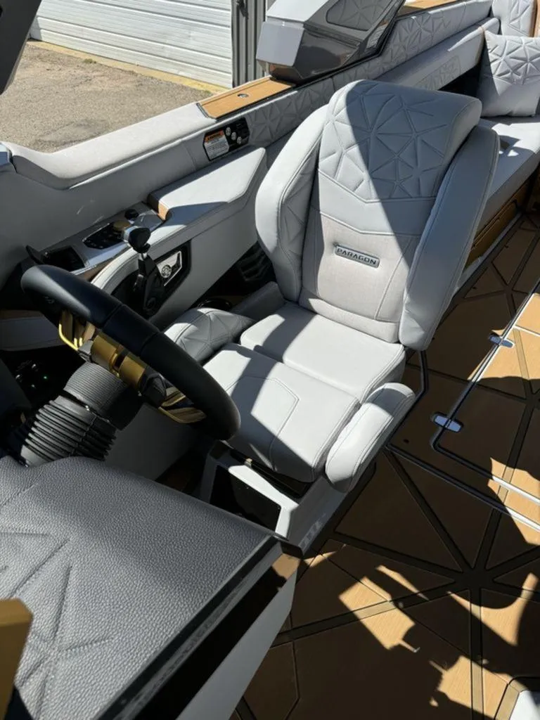 Slide: The Image of 2025 Nautique Paragon 25 interior with luxurious seating and modern steering wheel design. - 9
