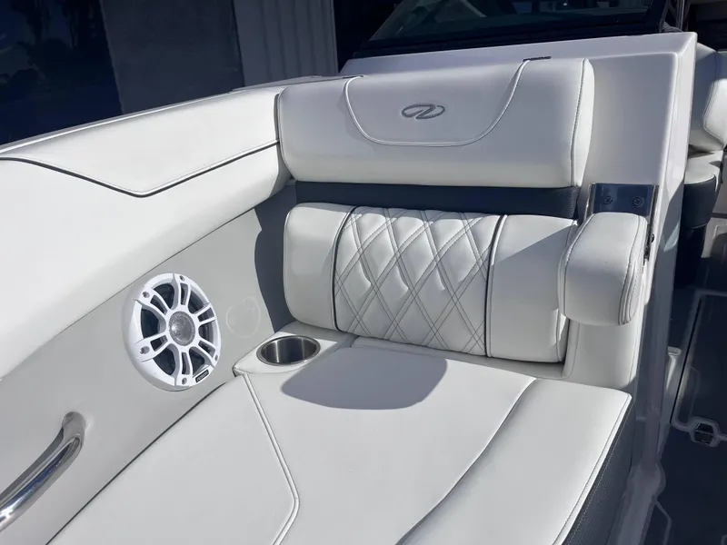 Slide: The Image of Luxurious white seating on 2022 Regal LS2-CM boat with speaker and cup holder. - 7