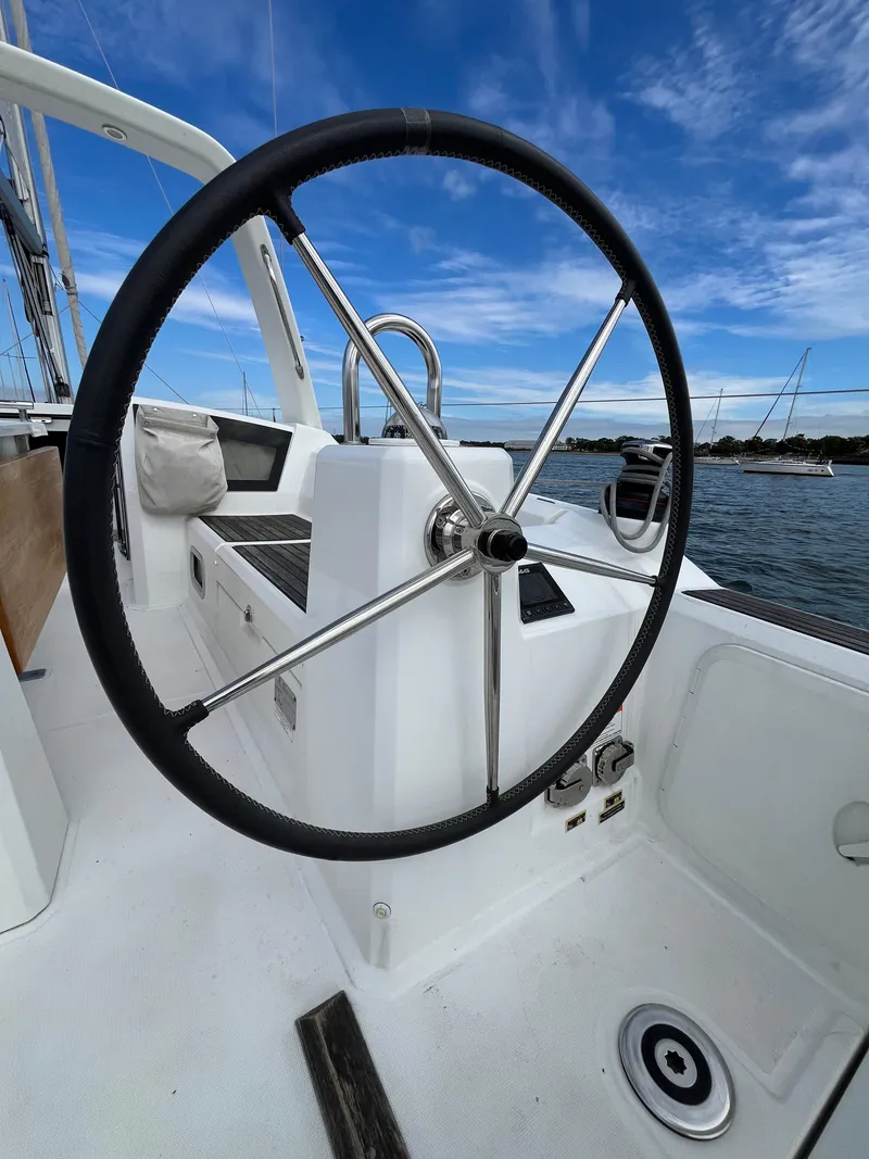 Slide: The Image of Steering wheel of 2018 Beneteau Oceanis 35.1 sailboat against a clear blue sky. - 10