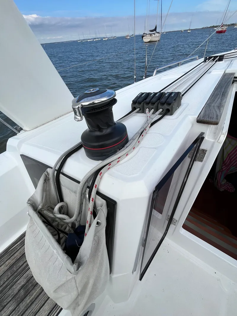 Slide: The Image of 2018 Beneteau Oceanis 35.1 sailboat deck with winch and ropes, moored in a marina. - 15