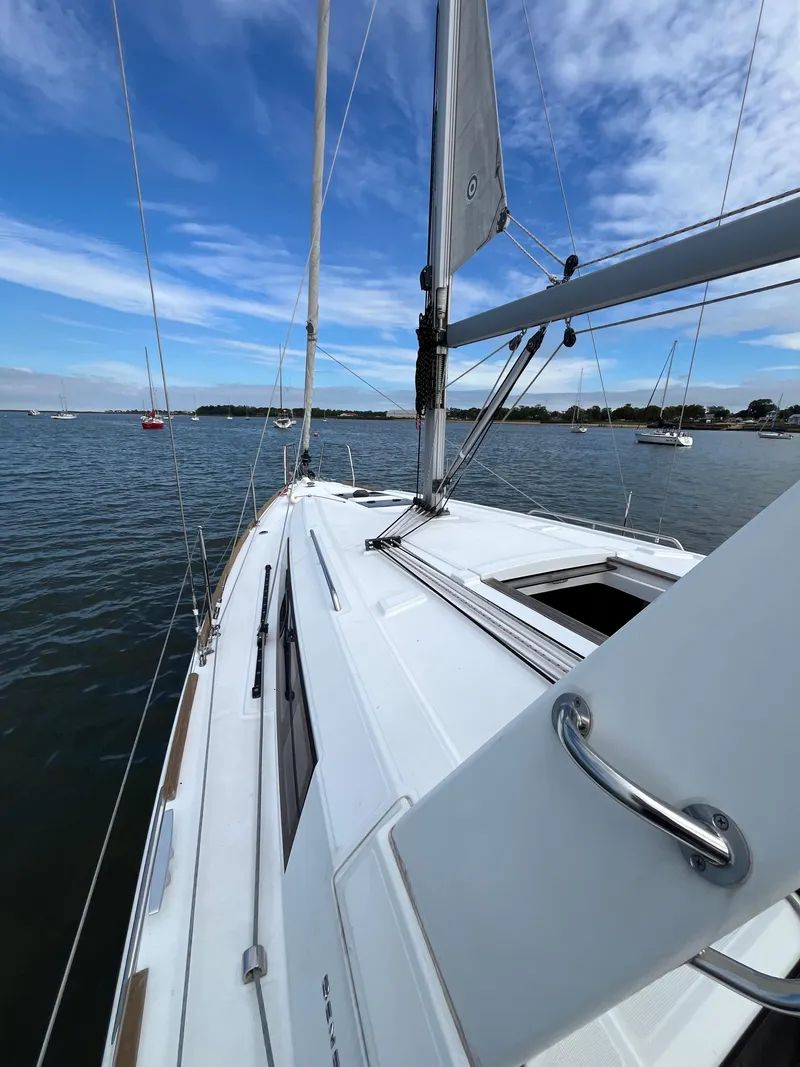 Slide: The Image of 2018 Beneteau Oceanis 35.1 sailboat on calm waters under a blue sky. - 16