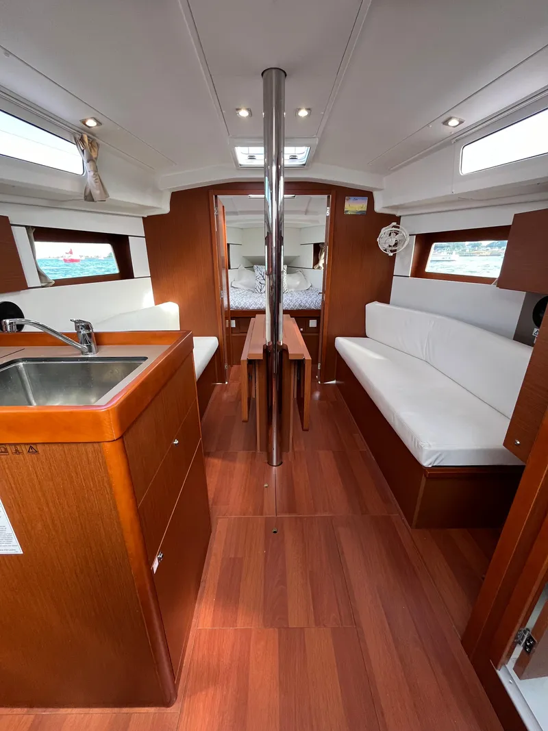 Slide: The Image of Interior of 2018 Beneteau Oceanis 35.1 yacht with wood finish and white seating. - 28