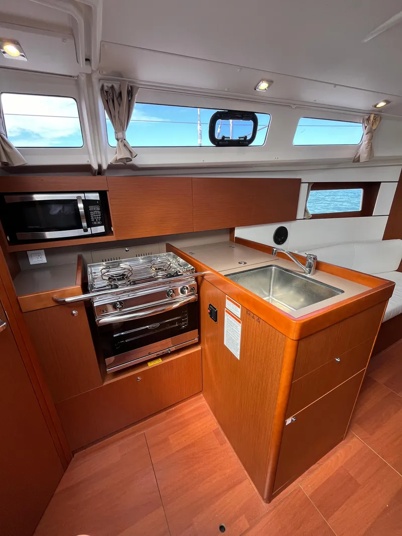 Slide: The Image of 2018 Beneteau Oceanis 35.1 yacht kitchen with stove, sink, and microwave. - 36