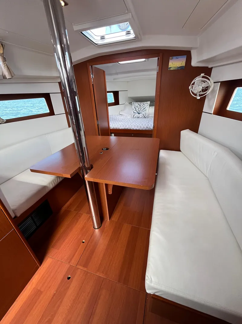 Slide: The Image of 2018 Beneteau Oceanis 35.1 interior with wood finish, white seating, and natural light. - 47