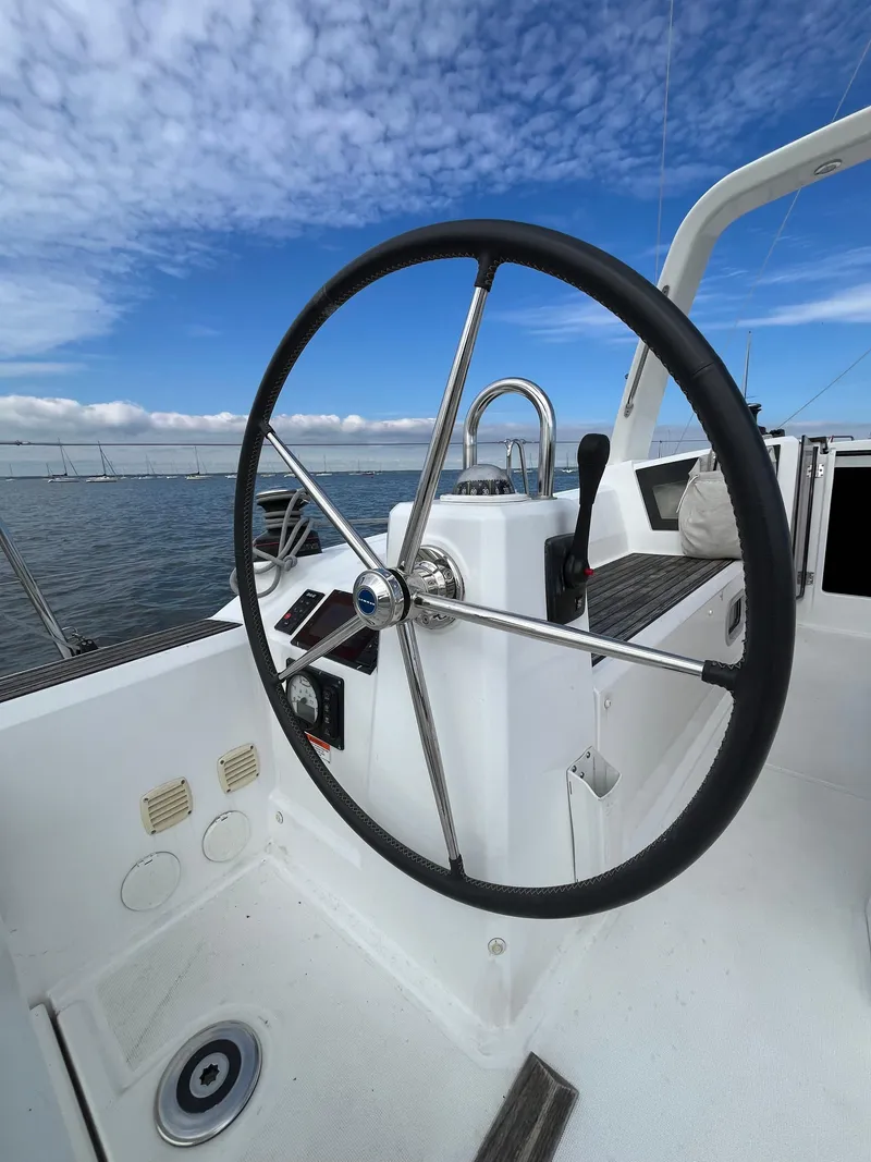 Slide: The Image of Steering wheel of 2018 Beneteau Oceanis 35.1 sailboat against a clear blue sky. - 7