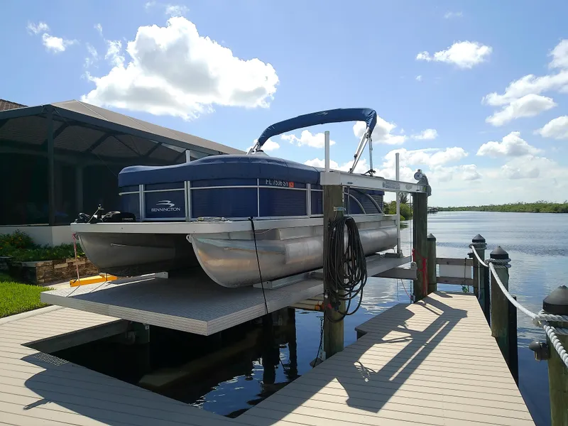 Slide: The Image of 2020 Bennington SV 20 SLV pontoon boat docked by a scenic waterfront. - 3