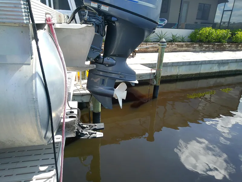 Slide: The Image of Bennington SV 20 SLV 2020 boat motor at dockside, reflecting in calm water. - 6