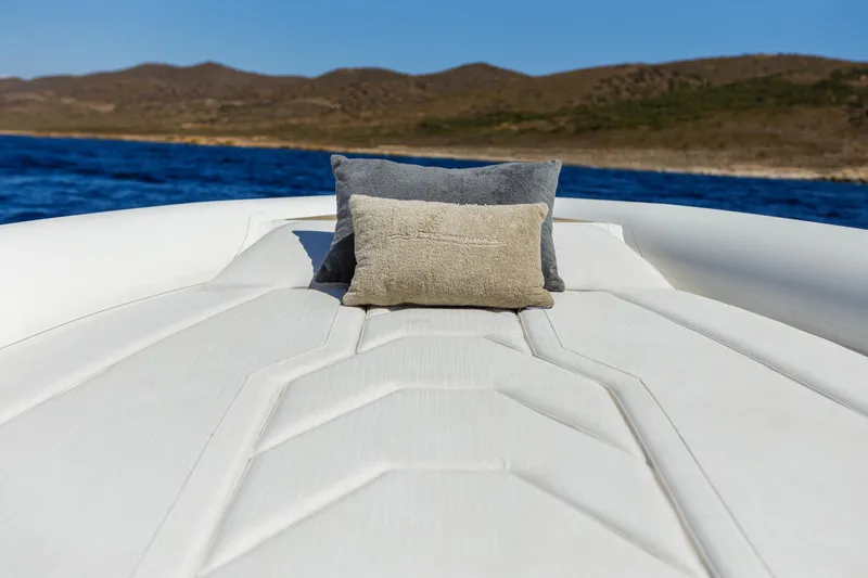 Slide: The Image of Luxurious Technohull Alpha 40 boat interior with cushions, 2025 model, on serene blue water. - 13