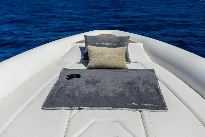 Slide: The Image of 2025 Technohull Alpha 40 boat deck with cushions and towel, set against a blue ocean backdrop. - 14