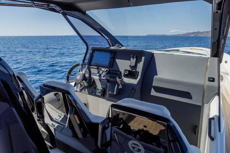 Slide: The Image of 2025 Technohull Alpha 40 cockpit with modern controls, steering wheel, and ocean view. - 8
