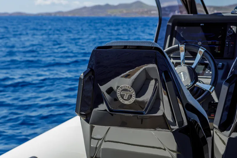 Slide: The Image of Technohull Alpha 40, 2025 model, sleek black helm, ocean backdrop. - 9