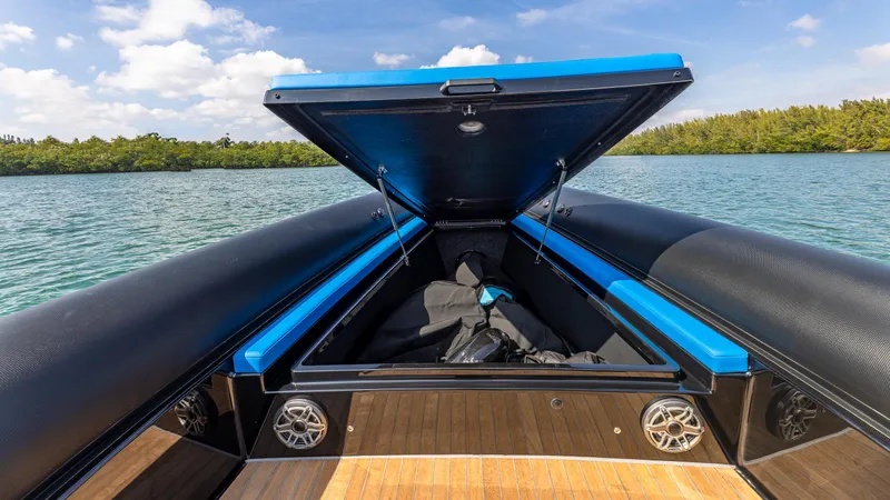 Slide: The Image of 2025 Technohull 38 Grand Sport boat with open storage compartment on a sunny day. - 13