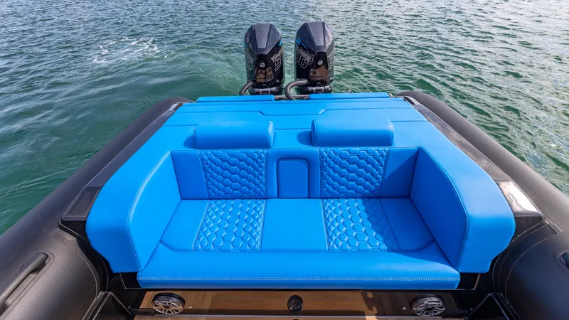 Slide: The Image of 2025 Technohull 38 Grand Sport with blue seating and dual engines on water. - 14