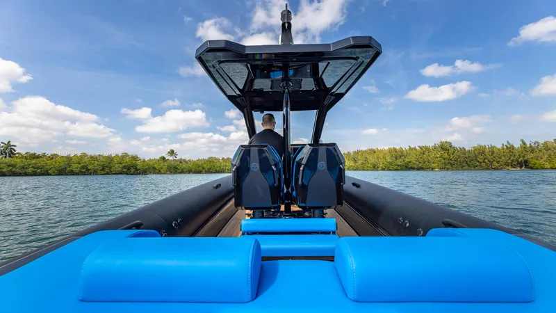 Slide: The Image of 2025 Technohull 38 Grand Sport boat on water, featuring sleek design and vibrant blue seating. - 16