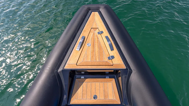 Slide: The Image of 2025 Technohull 38 Grand Sport boat with sleek wooden deck on calm water. - 11
