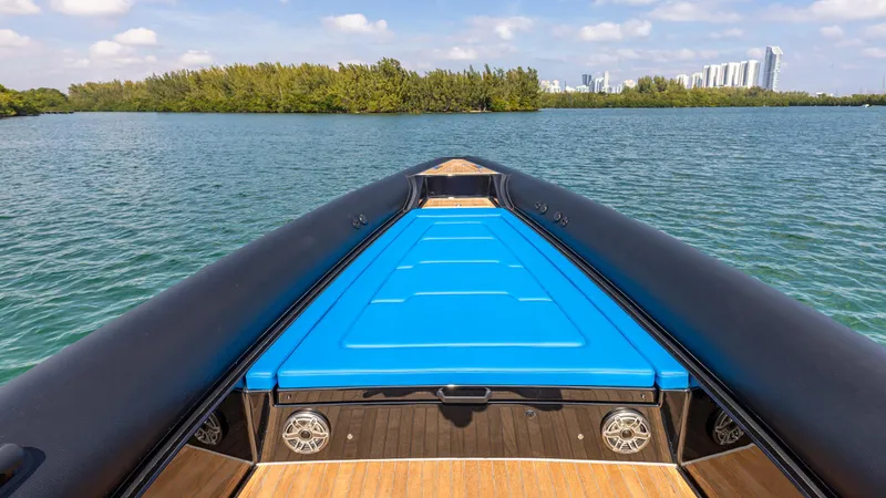 Slide: The Image of 2025 Technohull 38 Grand Sport boat on serene water with city skyline. - 12