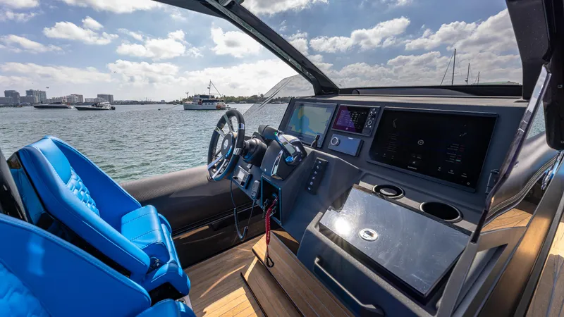 Slide: The Image of 2025 Technohull 38 Grand Sport cockpit with modern controls and blue seating on open water. - 24