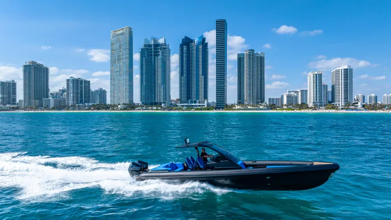 Slide: The Image of Technohull 38 Grand Sport 2025 cruising near city skyline on blue ocean waters. - 4